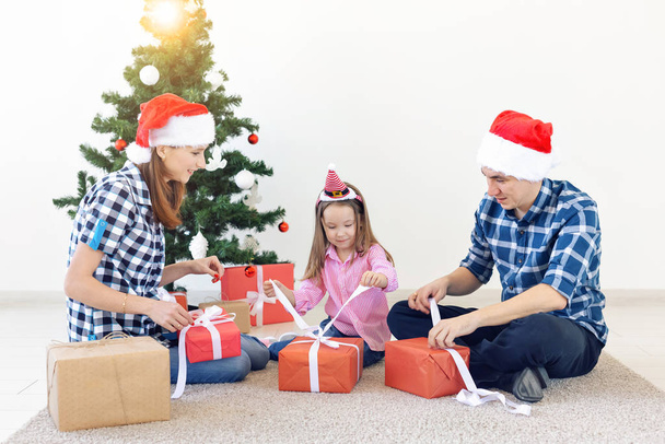 Vakantie en presenteert concept - Portret van een gelukkig gezin opening geschenken in de kersttijd - Foto, afbeelding