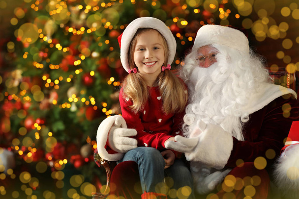 Santa Claus and little girl near Christmas tree indoors - Fotoğraf, Görsel