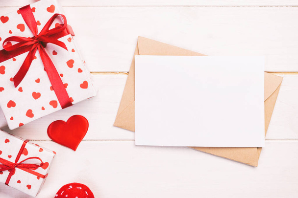 Boríték levél piros szív és ajándék doboz alatt fehér fa háttér. Valentin-napi üdvözlőlap, szerelem, vagy esküvői köszöntő koncepció - Fotó, kép