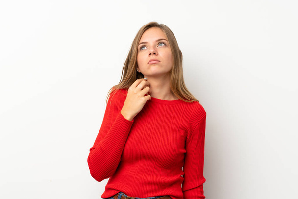 Молодая блондинка в красном свитере на изолированном белом фоне думает об идее
 - Фото, изображение