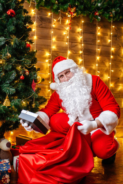 Santa Claus near Christmas tree with gifts. Christmas time - Foto, Imagem