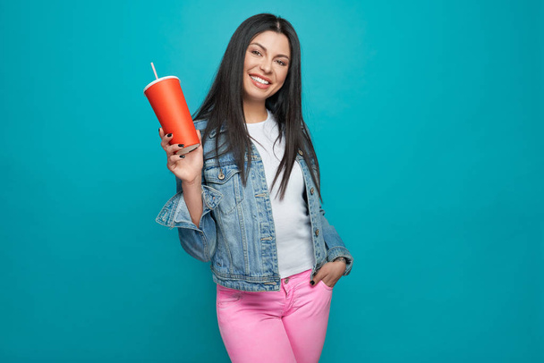 Stylish girl posing in trendy clothes with red cup. - Фото, зображення