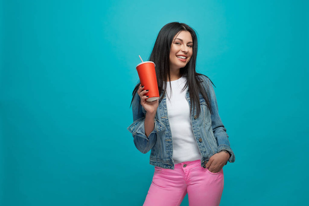 Girl wearing in stylish clothes holding red paper cup. - Photo, Image
