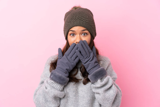 Young Colombian girl with winter hat over isolated pink wall with surprise facial expression - Foto, Imagen