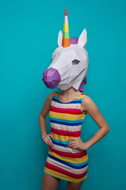 Girl with paper 3D unicorn on head holding hands on waist. - Foto, afbeelding