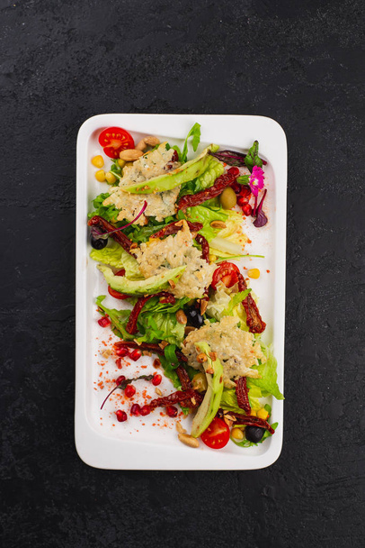 salade verte fraîche aux légumes grillés et fromage sur assiette blanche
  - Photo, image