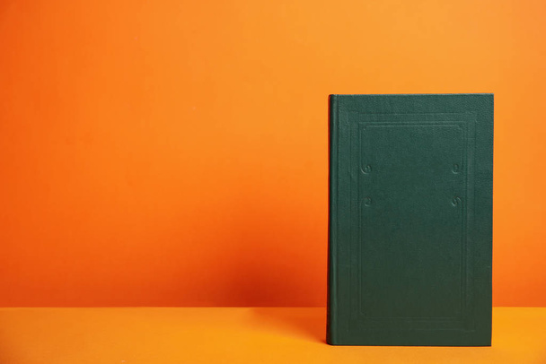 Hardcover book on orange background. Space for design - Photo, image