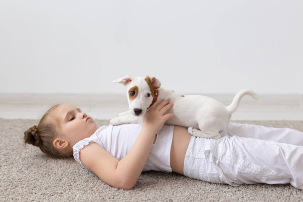 Lemmikit ja eläin käsite - Lapsi tyttö leikkii pentu Jack Russell Terrier
 - Valokuva, kuva