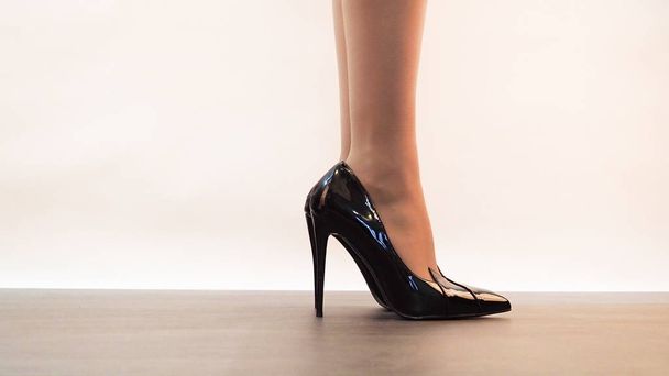 Close-up shot of pair of beautiful female legs wearing high heels - 写真・画像