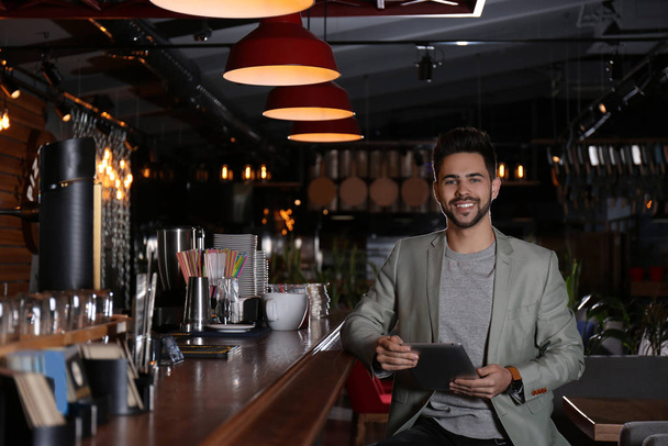 Young business owner with tablet in his cafe - Fotoğraf, Görsel