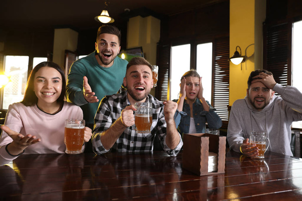 Group of friends watching football in sport bar - Фото, изображение