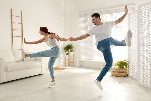 Beautiful young couple dancing in living room - Foto, imagen
