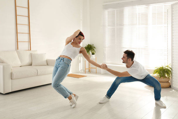 Beautiful young couple dancing in living room - Φωτογραφία, εικόνα