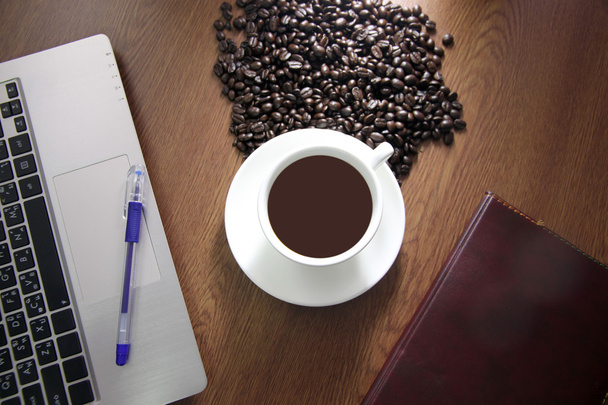 Kaffee in weißer Tasse und sehen Sie die Notebooks in der Nähe. - Foto, Bild