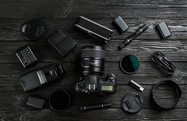 Composizione posata piatta con attrezzature per fotografo professionista su tavolo di legno nero
 - Foto, immagini