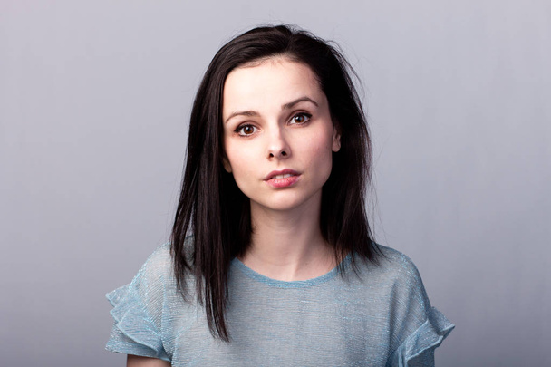 lovely girl in a blue t-shirt on a gray background emotion - Zdjęcie, obraz