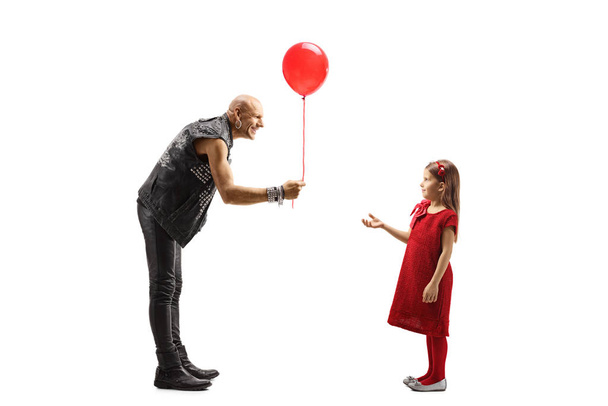 Rock star giving a red balloon to a little girl - 写真・画像