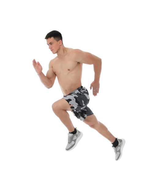 Athletic young man running on white background, side view - Foto, Bild