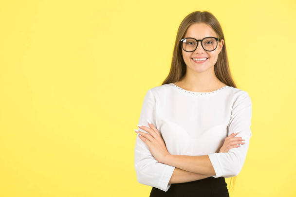 beautiful young woman in white shirt with glasses on yellow background - Photo, Image