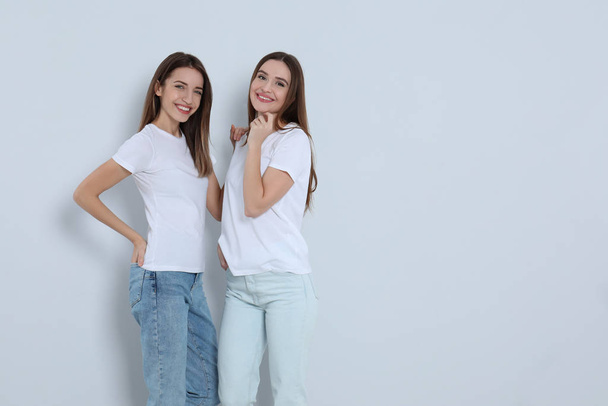 Jonge vrouwen in stijlvolle jeans op lichte achtergrond. Ruimte voor tekst - Foto, afbeelding