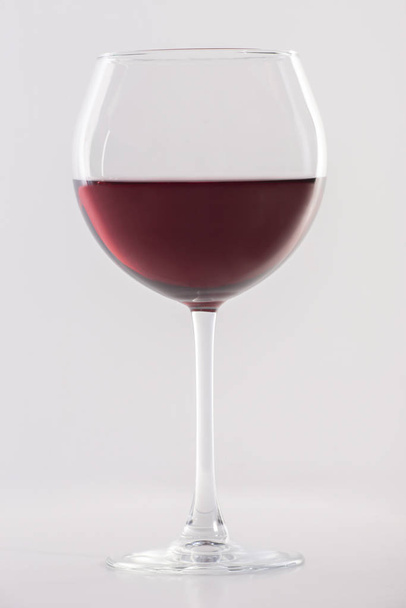 Glass of red wine on a white background and with soft shadow. - Фото, зображення
