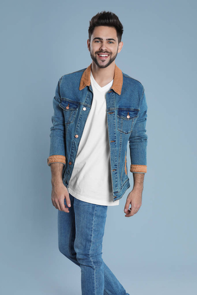 Young man in stylish jeans on grey background - Фото, зображення