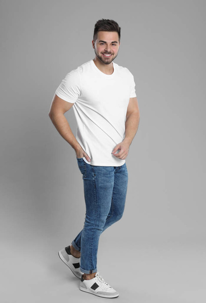 Young man in stylish jeans on grey background - Foto, Imagem