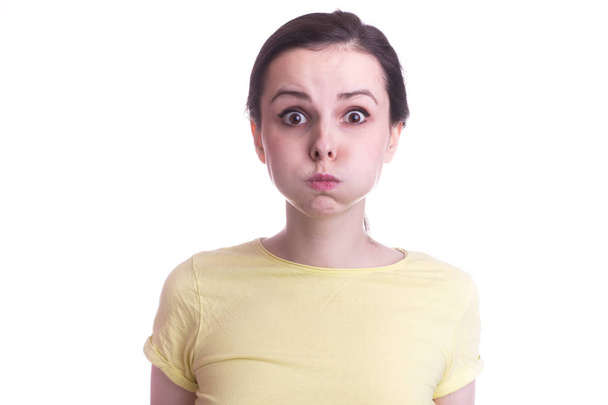 young emotional girl in a yellow t-shirt on a white background - Foto, Bild