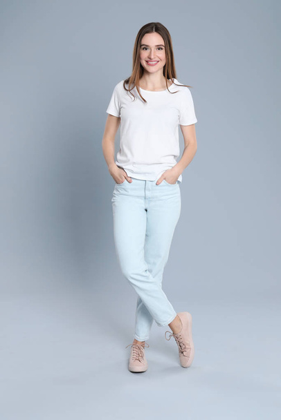 Young woman in stylish jeans on grey background - Photo, Image