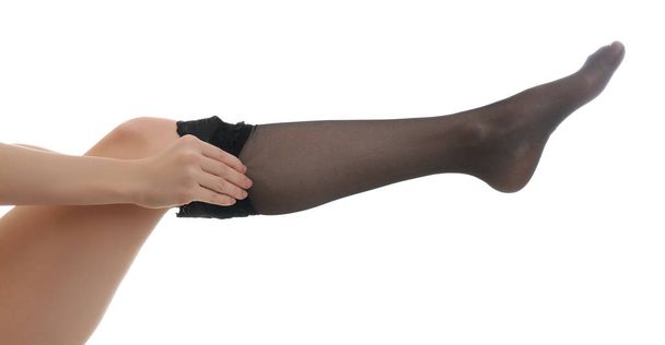 Young woman putting on stocking against white background, closeu - Foto, Imagem