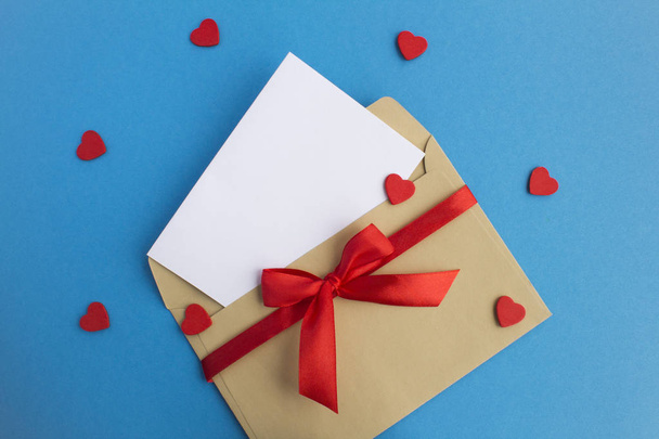 Blank white paper for text, envelope and red hearts on the blue background. Copy space. Top view. - Foto, imagen