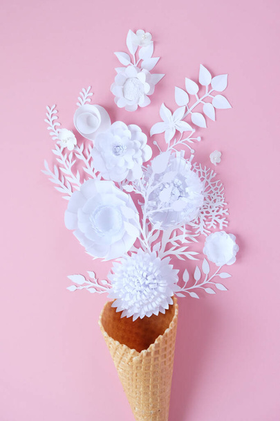 Waffle cone with paper flowers on pink background. Holiday concept. - Valokuva, kuva