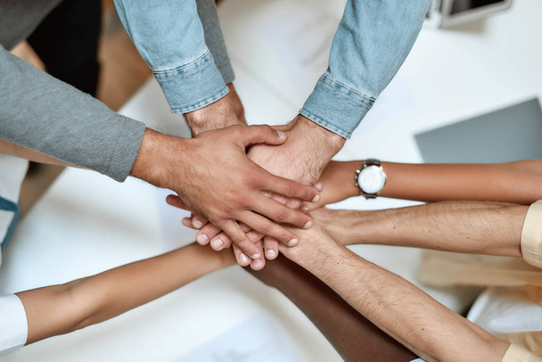 We always support each other. Multiracial group of people holding hands together isolated on white background - Foto, afbeelding