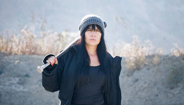 Жестокая женщина из банд хулиганов ходит с бейсбольной битой в пустыне. - Фото, изображение
