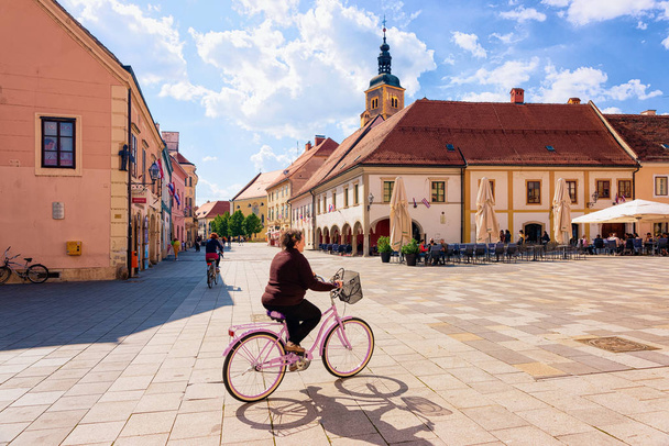 Senior woman on bicycle at Town Hall Varazdin - Foto, Imagem