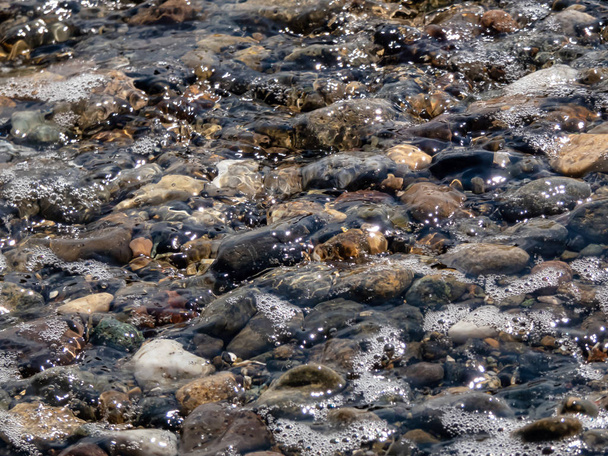 costa rocosa con marea que entra y sale sobre piedras
 - Foto, Imagen