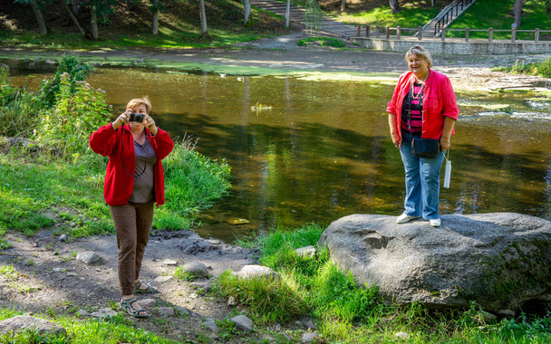 Mature femmes dodues en rouge se détendre et prendre des photos dans la ville Pa
 - Photo, image