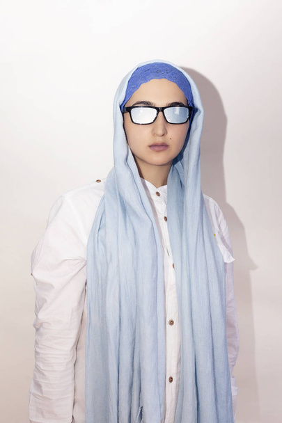 Stylish and elegant Muslim woman in traditional Islamic clothing. Portrait of beautiful Iranian girl in hijab and trendy sunglasses. Stock photo of Islamic clothing, fashion - Fotó, kép