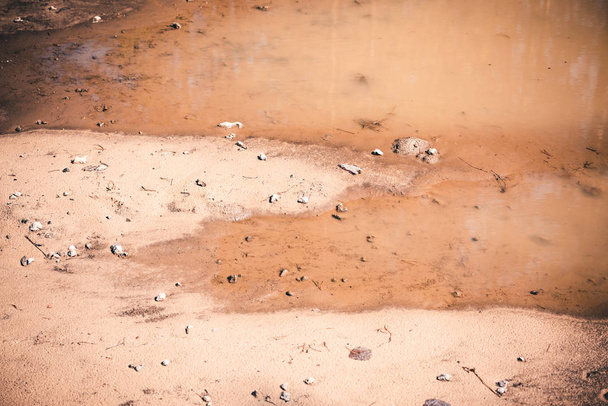 冬の後の雪解けによる砂道の深い春の水たまり - 写真・画像