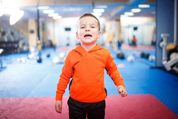 Portrait of a child posing in the gym. Theme is children's physical development. A sportsman boy in sportswear is looking at the camera. Childhood and Health - Fotoğraf, Görsel