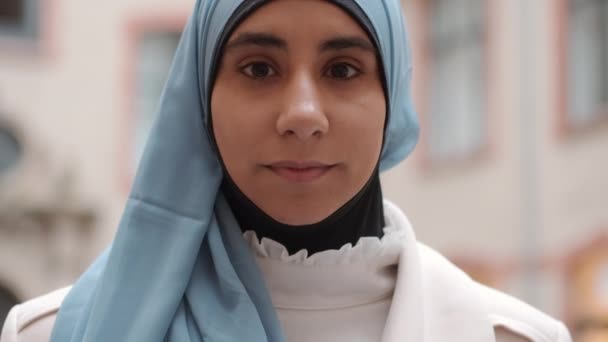 Retrato de la joven mujer árabe hermosa mirando atentamente en la cámara en la calle de la ciudad
 - Imágenes, Vídeo