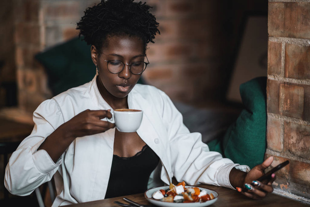 Black girl having lunch in a bar - Photo, image