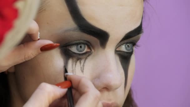 Easy Halloween Makeup. Girl in a beauty salon. Applying a stylistic pattern on the face of the model. The work of a master stylist. - Video, Çekim