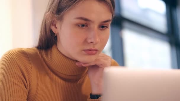 Κοντινό πλάνο της μαθήτριας κοπέλα με αυτοπεποίθηση μελέτη σε φορητό υπολογιστή στο καφέ  - Πλάνα, βίντεο