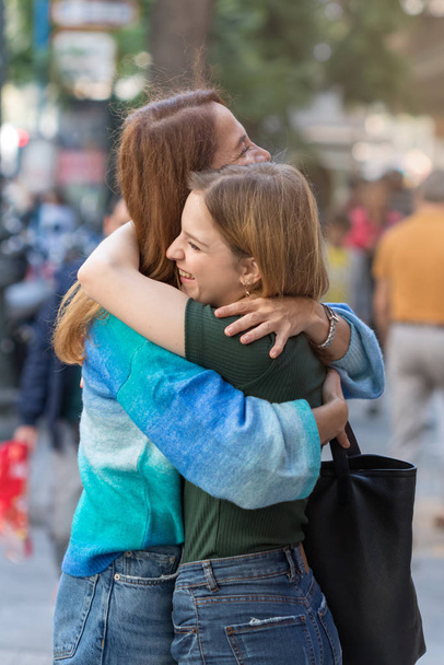 Mãe feliz e adolescente, abraçando um ao outro no steet
. - Foto, Imagem