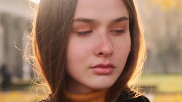 Portret van een prachtig sensueel meisje bedachtzaam rondkijkend in de buitenlucht bij zonsondergang park - Video