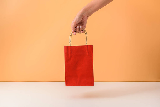 Female hand holding red papaer shopping bags - Foto, Bild
