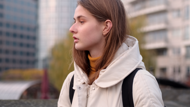 Gyönyörű alkalmi lány le kabát hátizsák séta a város utcáin - Felvétel, videó