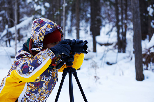 Женщина фотографирует в лесу. Зимняя погода. Интересная профессия живописца
. - Фото, изображение