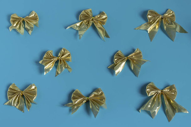 Décorations de Noël brillantes en or, branche d'épinette, boules pour le sapin de Noël, arcs, tinsel sur fond bleu, vue sur le dessus
 - Photo, image
